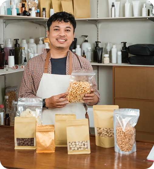 Smiling entrepreneur holding packaged snacks produced by Launch My Brand.